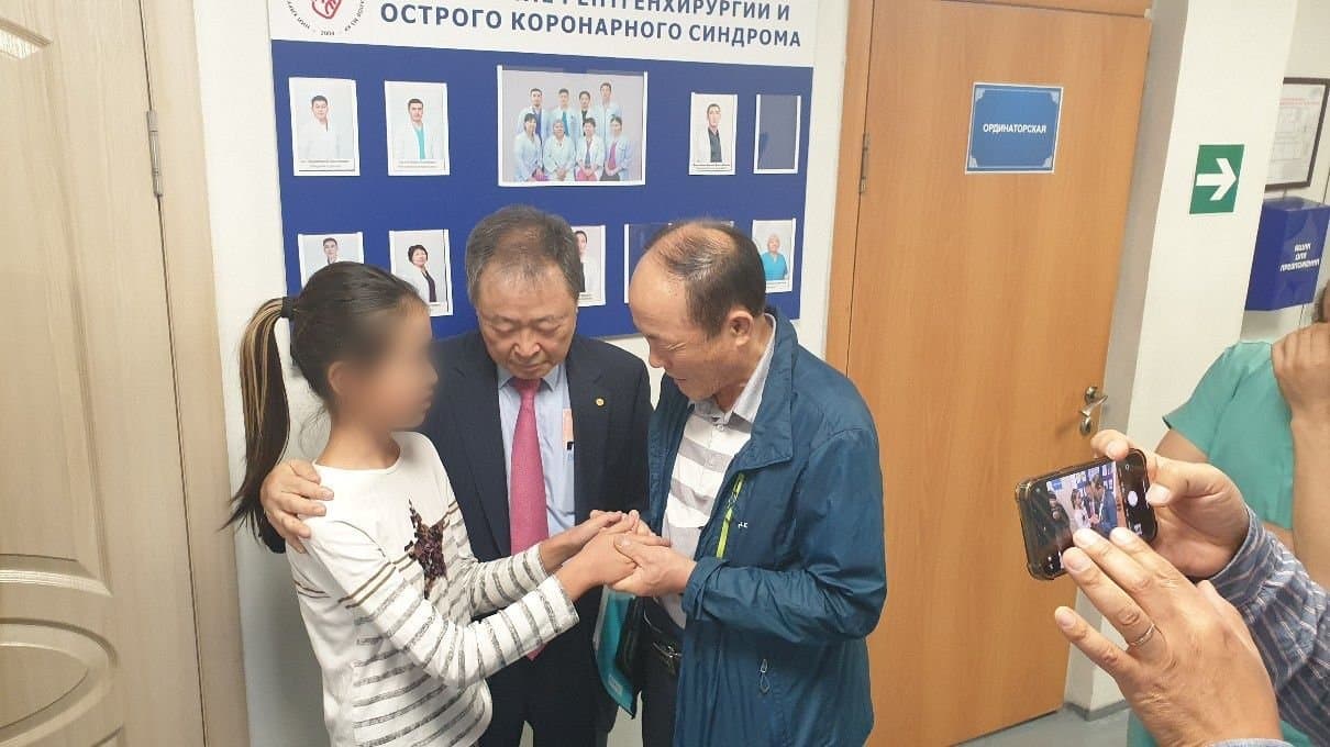 국립병원을 방문해 심장병 어린이의 손을 잡고 기도하는 모습